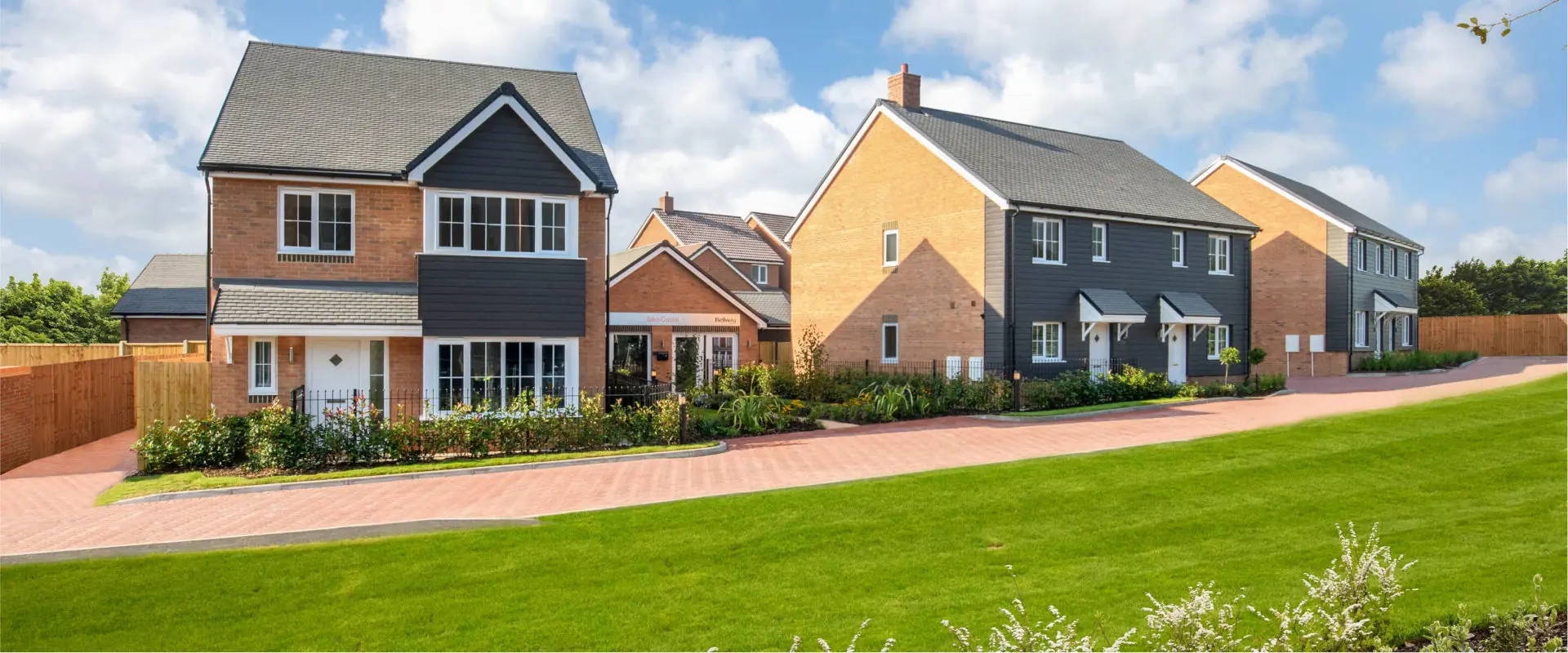 Bright blue sky, street, row of new Bellway homes